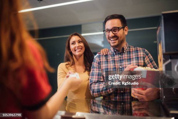 sonriente pareja comprar entradas de cine - ticket counter fotografías e imágenes de stock