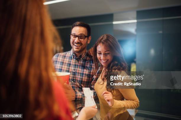 couple buying popcorn and tickets at cinema - movie counter stock pictures, royalty-free photos & images