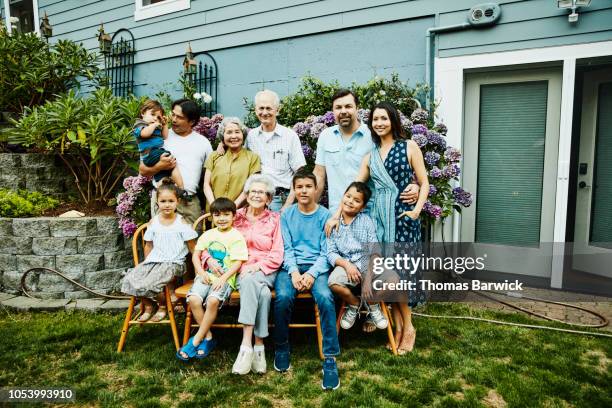 portrait of multigenerational family in backyard garden on summer evening - multi generation family photos imagens e fotografias de stock