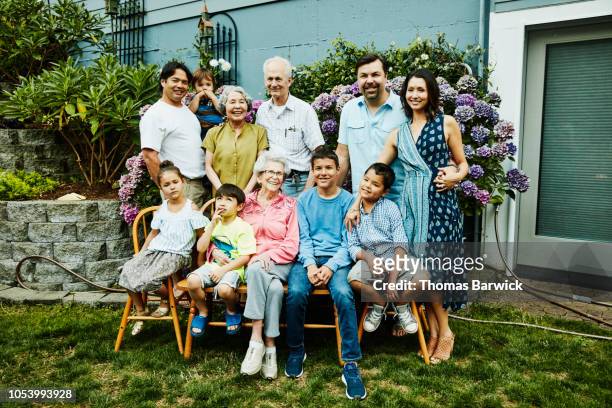 portrait of multigenerational family in backyard garden on summer evening - great grandmother photos et images de collection