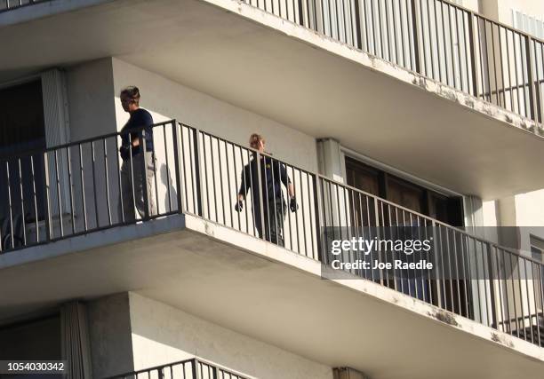 Agents walk on along the balcony of a condo in the building that has a possible connection to alleged bomber Cesar Sayoc and his mother on October...