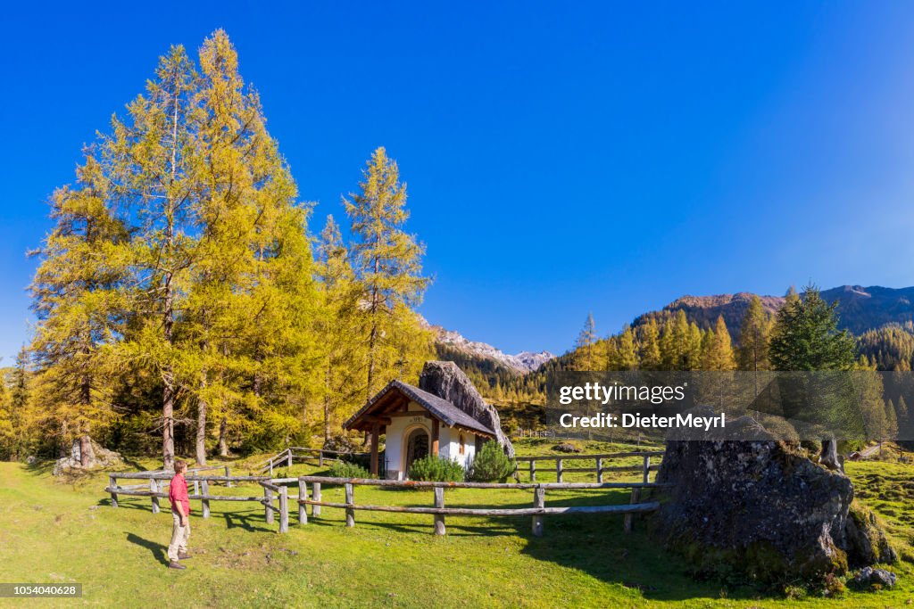 Hiker in Alps with Little Chapel in background - Forstau in the province of Salzburg