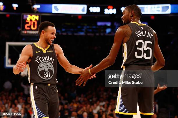 Stephen Curry of the Golden State Warriors celebrates with teammate Kevin Durant after hitting a three point basket against the New York Knicks...