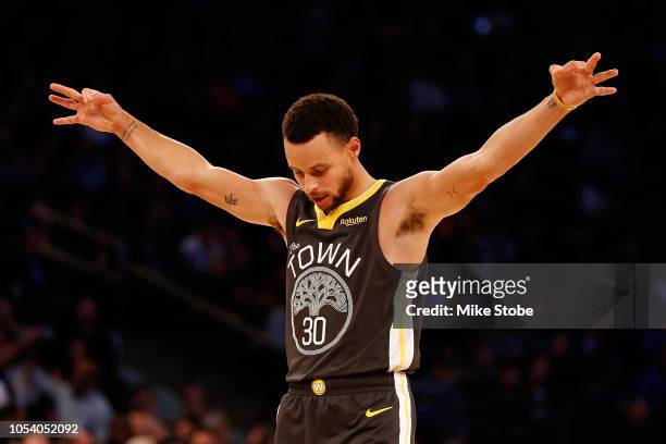 Stephen Curry of the Golden State Warriors celebrates after teammate Alfonzo McKinnie hits a three point basket against the New York Knicks during...