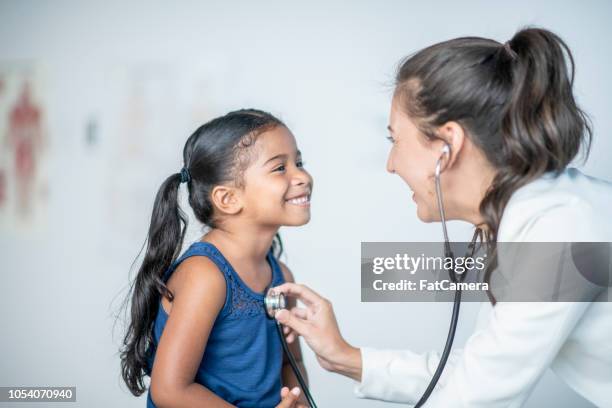 mädchen genießt ihr medizinischen checkup - doctor children stock-fotos und bilder