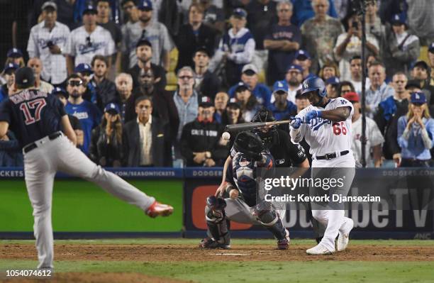 Yasiel Puig of the Los Angeles Dodgers hits a single on a pitch from Nathan Eovaldi of the Boston Red Sox that leads to the tying run during the...