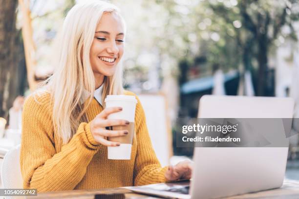 young woman using lap top at cafe - busy coffee shop stock pictures, royalty-free photos & images