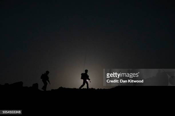 Personnel from 40 Commando, Royal Marines walk across a ridge with the moon setting behind during exercise 'Saif Sareea 3' on October 24, 2018 in...