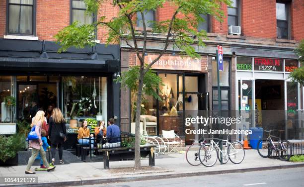 greenpoint, ny: millennials relax outside eatery - brooklyn store building stock pictures, royalty-free photos & images