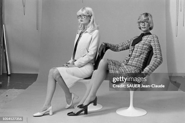 Pierre CARDIN présente les modèles de sa collection prêt à porter en janvier 1972. Deux mannequins assises, à gauche, portant un tailleur clair et...