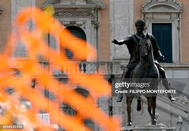 Roadwork net is held by demonstrators by the statue of Marco Aurelio in Rome 's Piazza del Campidoglio, on October 27, 2018 during a protest against...