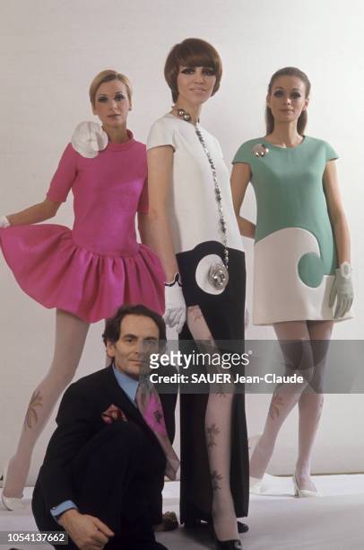 La mode Pierre Cardin s'exporte en Amérique. Ici les robes géométriques. Février 1969. Le couturier posant assis au pied de trois de ses modèles : au...