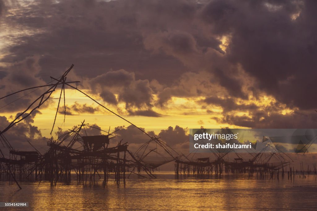 Traditional fishing nets over cloudy sunrise at Phatthalung, Thailand.