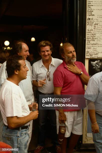 Saint-Tropez, France - Août 1985 - Le chanteur Eddy MITCHELL en vacances avec son épouse Muriel et leur fille Pamela. Ici, souriant, un verre à la...