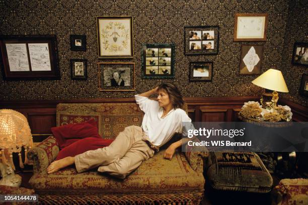 Paris, France - Septembre 1985 - Jane BIRKIN chez elle, dans sa maison du 16ème arrondissement. Ici, posant allongée dans une banquette ancienne,...