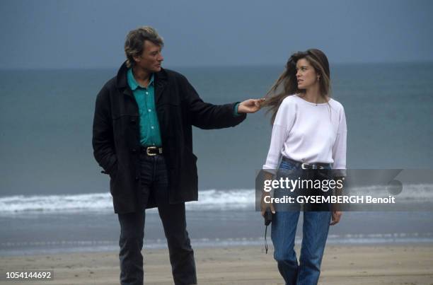 Tournage de l'émission "Embarquement immédiat" en Irlande. Mai 1987. Johnny HALLYDAY tenant une mèche de cheveux de Corynne CHARBY, tandis qu'ils...