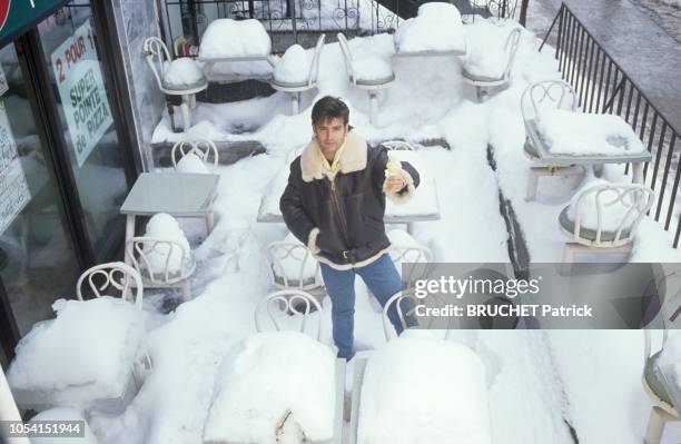 Québec, Canada - 20 janvier 1991 - Le chanteur Roch VOISINE chez lui près de Montréal. Ici, mangeant un cornet de glace sur une terrasse couverte de...