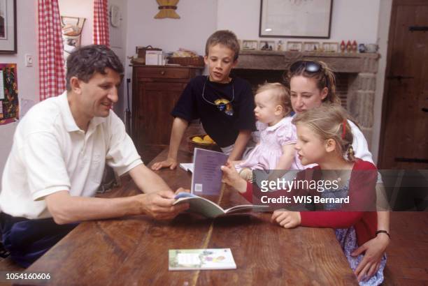 Vendée, France - 12 juin 1994 - L'homme politique Philippe DE VILLIERS en séance de lecture autour d'une table, avec quatre de leurs sept enfants :...