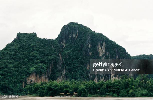 Juillet 2000 --- Le fleuve Mékong au Laos. Ici, un massif rocheux couvert de végétation, participant à la variété du paysage et de son relief, sur...