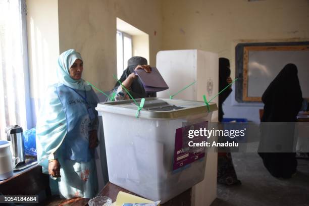 An Afghani voter casts her ballot for the parliamentary elections, one week later than the rest of the country, delayed due to a high-profile...