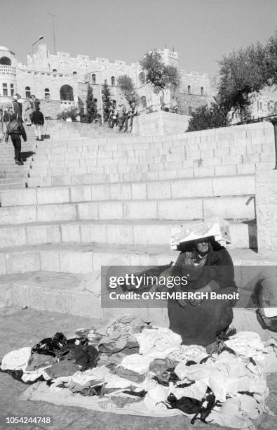 Jérusalem, Israël, novembre 2000 --- La population arabe de Jérusalem. Scènes de marché. Une femme arabe s'abritant du soleil avec une cagette vide...