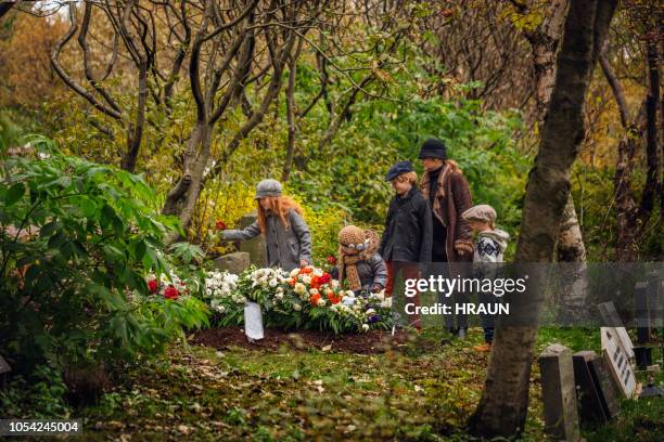 famiglia in visita tomba di defunto amato uno. - tomba luogo di sepoltura foto e immagini stock