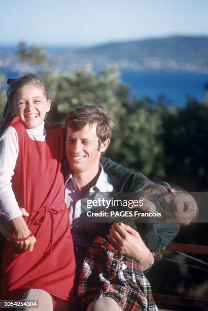 Août 1964 --- Jean-Paul BELMONDO en vacances en famille avec son épouse Elodie et leurs trois enfants Patricia, Florence et Paul : l'acteur serrant...