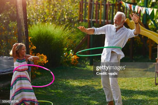 multi generation family hula hooping in backyard - jogar ao arco imagens e fotografias de stock