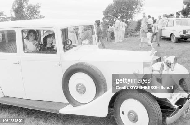 Nairobi, Kenya, circa 1989 --- Le concours d'élégance de voitures anciennes à l'hippodrome de Nairobi. Une femme conduisant une voiture de collection...