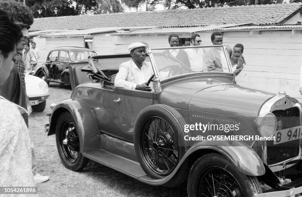 Nairobi, Kenya, circa 1989 --- Le concours d'élégance de voitures anciennes à l'hippodrome de Nairobi. Un kényan portant un costume et une casquette...
