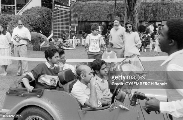 Nairobi, Kenya, circa 1989 --- Le concours d'élégance de voitures anciennes à l'hippodrome de Nairobi. Quatre jeunes gens à bord d'une voiture de...