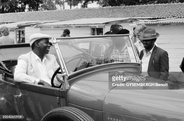 Nairobi, Kenya, circa 1989 --- Le concours d'élégance de voitures anciennes à l'hippodrome de Nairobi. Un kényan au volant d'une voiture de...