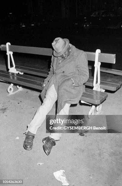 Paris, France, circa 1978 --- Les sans domicile fixe sur les quais de la Seine. Un homme dort, assis sur un banc la nuit.