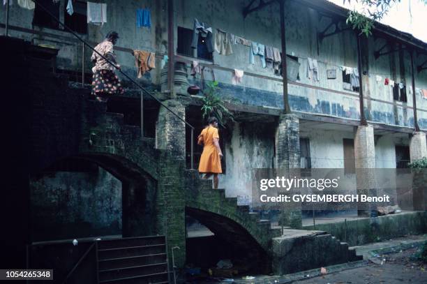 Ancien bagne de Cayenne en Guyane en 1983. Une femme et une petite fille vêtue d'une robe jaune, descendent un escalier, à l'extérieur de l'ancienne...