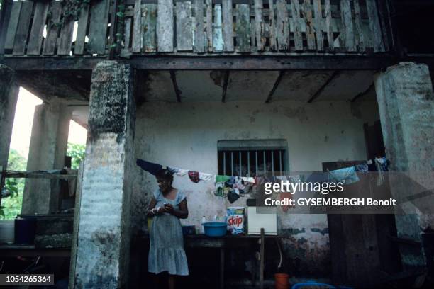 Ancien bagne de Cayenne en Guyane en 1983. Une femme préparant à manger dans une cuisine bricolée à l'extérieur de l'ancienne prison, où sèche...
