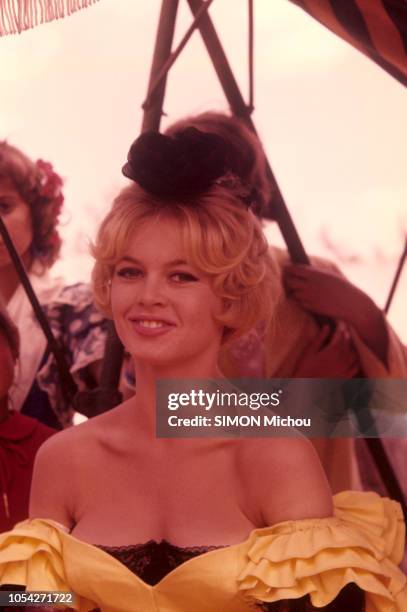 Séville, Espagne - 26 avril 1958 - Brigitte BARDOT, en robe jaune décolletée, un noeud noir dans les cheveux, sur le tournage de la "La Femme et le...