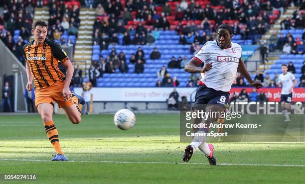 Bolton Wanderers' Clayton Donaldson shoots under pressure from Hull City's Tommy Elphick at Macron Stadium on October 27, 2018 in Bolton, England.