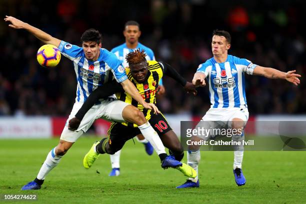 Isaac Success of Watford is challenged by Christopher Schindler of Huddersfield Town and Jonathan Hogg of Huddersfield Town during the Premier League...