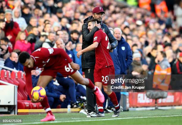 Jurgen Klopp, Manager of Liverpool greets Adam Lallana of Liverpool as Adam Lallana is substituted off during the Premier League match between...