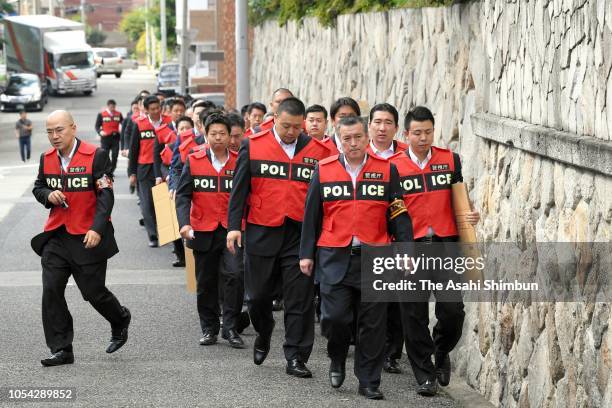 Police officers enter the yakuza syndicate Yamaguchi-Gumi headquarters over fraud cases on October 09, 2018 in Kobe, Hyogo, Japan.