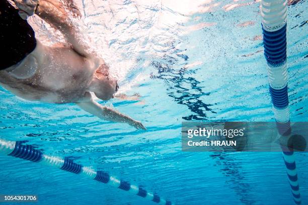 man with stoma bag swimming underwater in pool - swimming lanes stock pictures, royalty-free photos & images