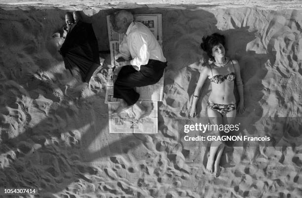 Le 14ème Festival de Cannes se déroule du 3 au 18 mai 1961 : vue de dessus d'une miss, Lydia HUET allongée en maillot de bain sur la plage à côté...