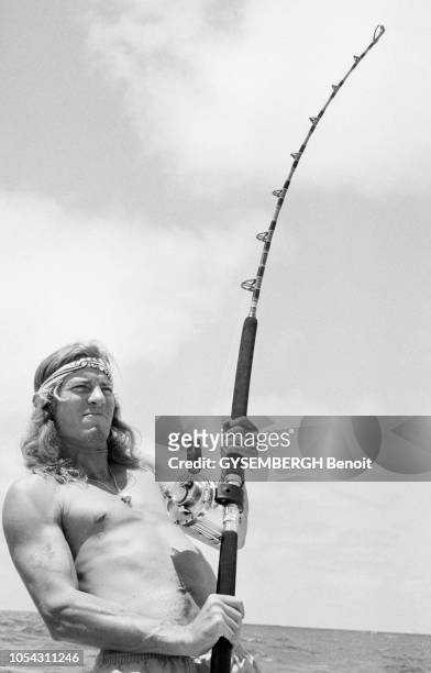 Etats-Unis, mai 1987 --- La pêche au gros dans l'océan Pacifique, au large de la Californie. Un pêcheur à la ligne, torse nu, luttant pour remonter...
