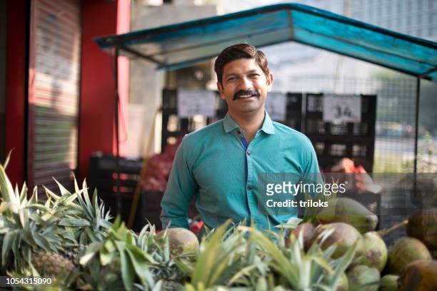 man selling pineapple and coconut - indian shopkeeper stock pictures, royalty-free photos & images