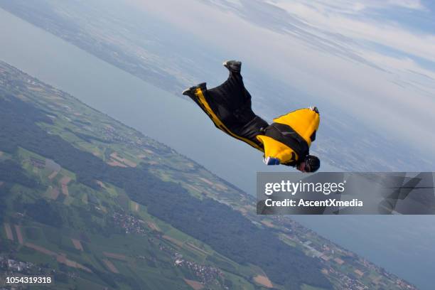 wingsuit flier dives mid-air - wing suit stock pictures, royalty-free photos & images