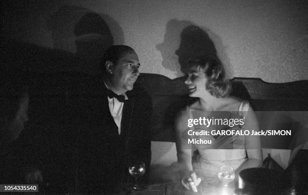 Le 9ème Festival de CANNES 1956 s'est déroulé du 23 avril au 10 mai : attitude souriante d'Ingrid BERGMAN une cigarette à la main, assise aux côtés...