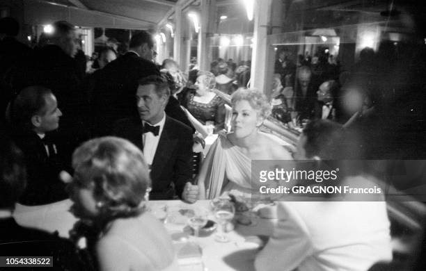 Le 12ème Festival de Cannes se déroule du 30 avril au 15 mai 1959 : Cary GRANT dînant aux côtés de Kim NOVAK avec des personnes non identifiées lors...