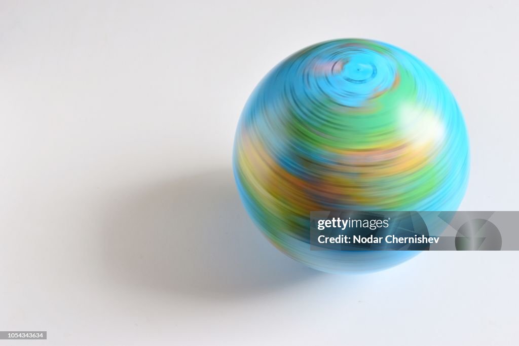 Blurred Motion Of Globe Spinning Over White Background