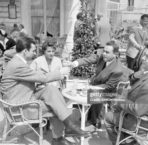 Le 6ème Festival de Cannes 1953 se déroule du 15 au 29 avril : Henri-Georges CLOUZOT assis à la terrasse d'un café, tendant un verre à Yves MONTAND,...