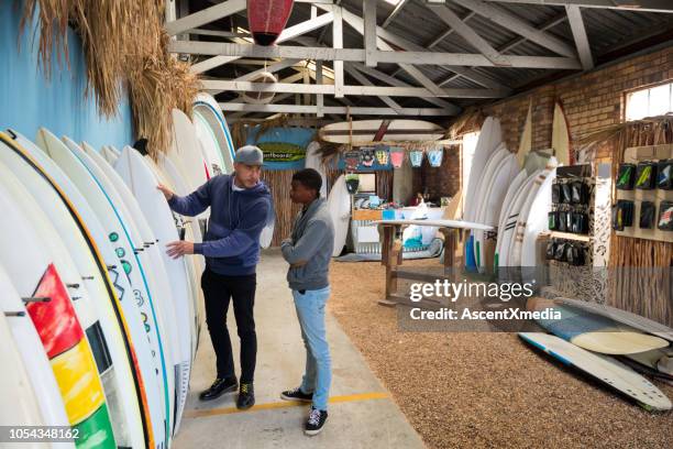 small business owner doing sales in his surf shop - sports equipment store stock pictures, royalty-free photos & images